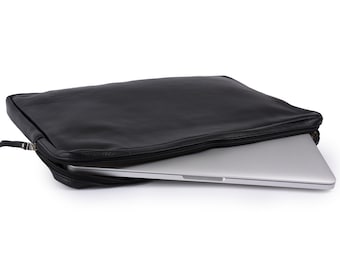 May include: A black leather laptop sleeve with a zipper closure. The sleeve is open and a silver laptop is partially visible inside.