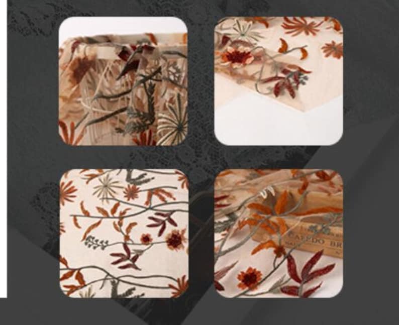 May include: Close-up of a beige sheer fabric with embroidered floral designs in shades of orange, brown, and green. The fabric has a delicate, airy texture.