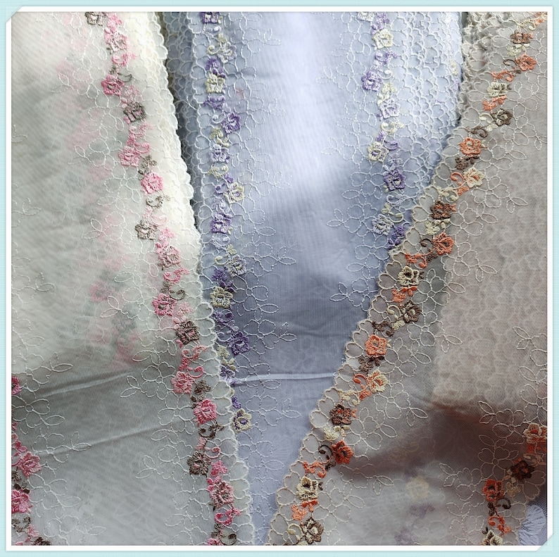 May include: Three pieces of sheer fabric with delicate floral lace trim in shades of white, pink, and purple.