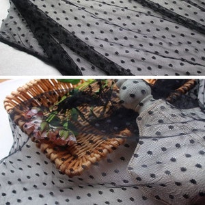 May include: Black sheer fabric with small white polka dots. The fabric is delicate and has a soft texture.