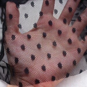 May include: Black sheer fabric with small black polka dots. The fabric is delicate and has a soft texture.