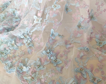 May include: Pale blue and pink embroidered butterflies on a sheer white fabric. The butterflies are 3D and have a delicate, feminine look.