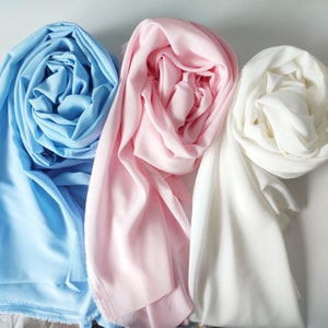 May include: Three rolls of fabric in different colors: light blue, pink, and white. The fabric is soft and smooth, and it is perfect for sewing or crafting.