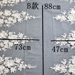 May include: White floral lace fabric with a 3D effect. The fabric is 73cm wide and 88cm long. The fabric is on a gray background. The text 'B款 88cm' is written on the fabric.