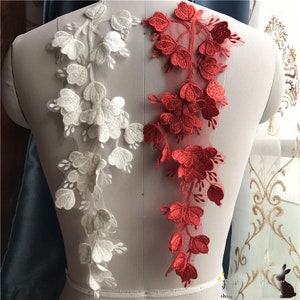 Puede incluir: Dos piezas de encaje floral blanco y rojo. El encaje es delicado y presenta un diseño floral. El encaje es perfecto para agregar un toque de elegancia a cualquier proyecto.
