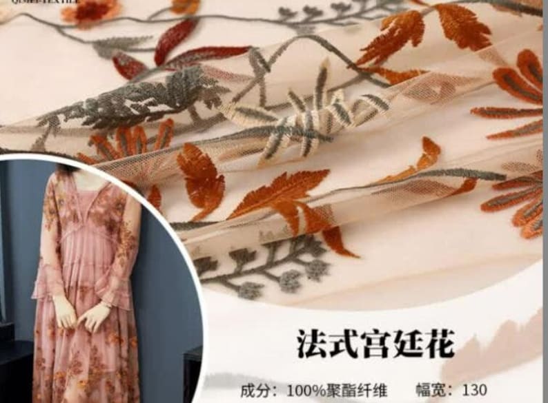 May include: Beige sheer fabric with embroidered floral designs in shades of orange, brown, and gray. The fabric is 100% polyester and has a width of 130 cm.