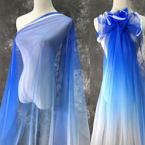 May include: A sheer blue ombre fabric with a gradient from white to blue. The fabric is draped over a mannequin and is very lightweight and translucent.