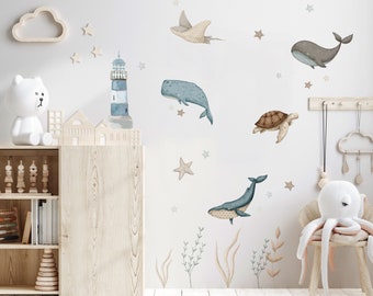 May include: A nursery room decorated with a blue and white lighthouse, whales, a turtle, a stingray, and starfish wall decals. The room also features a wooden shelf with books and toys, a white cloud-shaped shelf, and a brown rug.