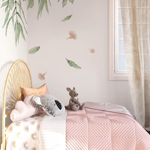 May include: A pink and white bed with a white and gold rainbow patterned sheet and a pink quilted blanket. The bed has a wicker headboard and a stuffed kangaroo and koala on the bed. The wall behind the bed has a floral decal with pink flowers and green leaves.