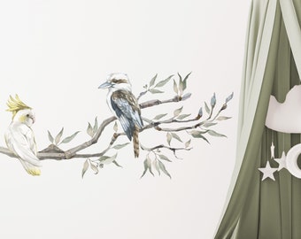 May include: A watercolor-style wall decal featuring a kookaburra and a cockatoo perched on a branch with green leaves. The decal is perfect for adding a touch of nature to any room.