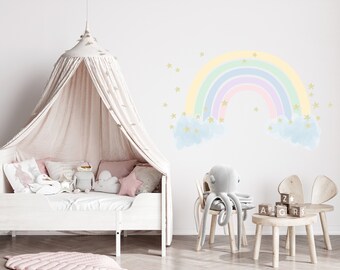 May include: A white canopy bed with a pink and white patterned rug in front of it. The wall behind the bed has a rainbow and cloud wall decal with gold stars. There is a gray octopus plush toy sitting on a wooden chair.