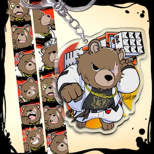 Puede incluir: Un personaje de dibujos animados de oso marrón que lleva un kimono de karate blanco, una cadena de oro y pantalones negros. El oso sostiene una cinta de casete roja y negra con la palabra japonesa "拳" (puño) en ella. El oso tiene una cicatriz sobre su ojo derecho y está levantando el puño. El fondo es un degradado rojo y naranja con la palabra "TigerLion" en texto blanco. El oso es un llavero.