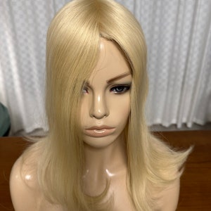Puede incluir: Un topper de cabello humano rubio con un estilo recto y en capas. El topper est&aacute; dise&ntilde;ado para agregar volumen y longitud a la coronilla de la cabeza.