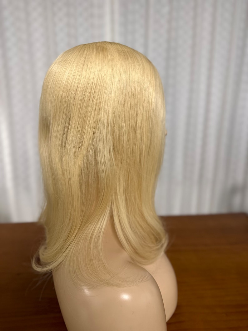 Puede incluir: Un topper de cabello humano rubio con cabello lacio y largo. El topper est&aacute; en una cabeza de maniqu&iacute;.