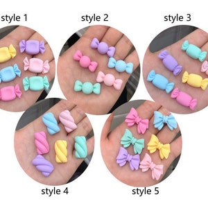 May include: Five different styles of pastel-colored candy and bow-shaped charms.  Style 1, 2, and 3 feature candy charms in various pastel colors. Style 4 features pastel-colored swirl charms. Style 5 features pastel-colored bow charms.