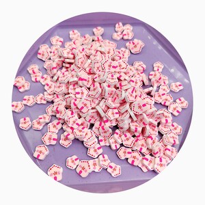 Piccola fetta di finta argilla polimerica rosa a forma di casa di pan di zenzero natalizia