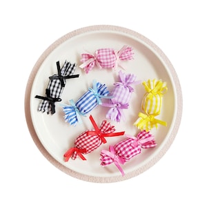 May include: Assortment of colorful gingham fabric candy shapes with black and white gingham, red and white gingham, blue and white gingham, pink and white gingham, purple and white gingham, and yellow and white gingham.