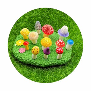 May include: A collection of miniature mushroom figurines in various colors, including red, yellow, purple, blue, and white, arranged on a bed of green artificial grass.