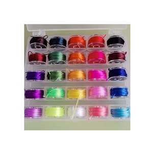 May include: A clear plastic storage box filled with 24 spools of colorful thread. The spools are arranged in rows and are all the same size. The thread colors include red, orange, yellow, green, blue, purple, pink, white, and black.