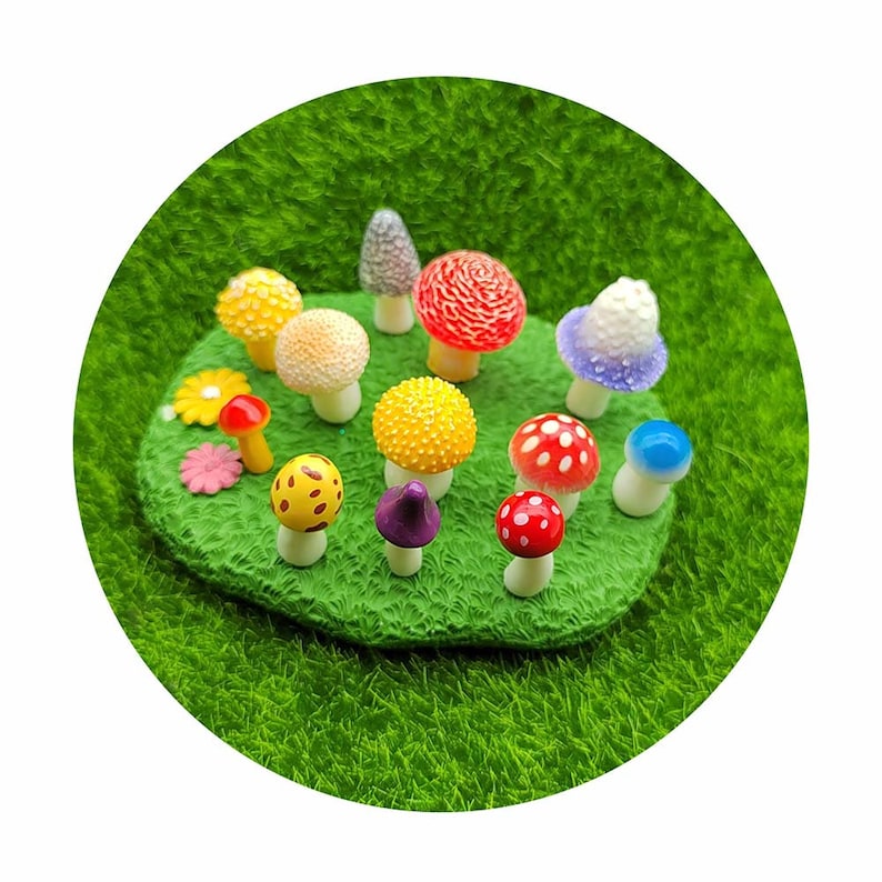 May include: A collection of miniature mushroom figurines in various colors and patterns, including red with white dots, yellow with white dots, purple, and blue. The figurines are arranged on a green grass-like surface.