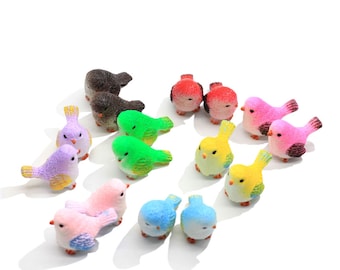 May include: A set of twelve miniature bird figurines in various colors, including pink, purple, green, yellow, blue, and red. The birds are made of a smooth, textured material and are perfect for adding a touch of whimsy to a miniature garden or fairy garden.