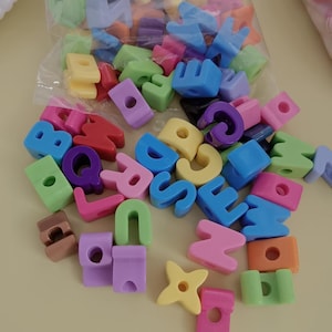 Cuentas con letras de colores variados y agujeros grandes para bolígrafos, llaveros y manualidades.