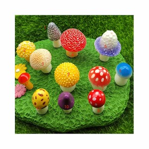 May include: A set of 10 miniature mushroom figurines in various colors and designs, including red with white dots, yellow with dots, purple, blue, and white with purple accents. The mushrooms are arranged on a green grassy surface.