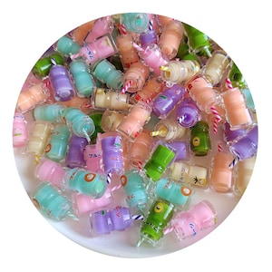May include: A collection of colorful miniature plastic bottles with straws and Japanese text. The bottles are filled with a variety of colors and have different designs.