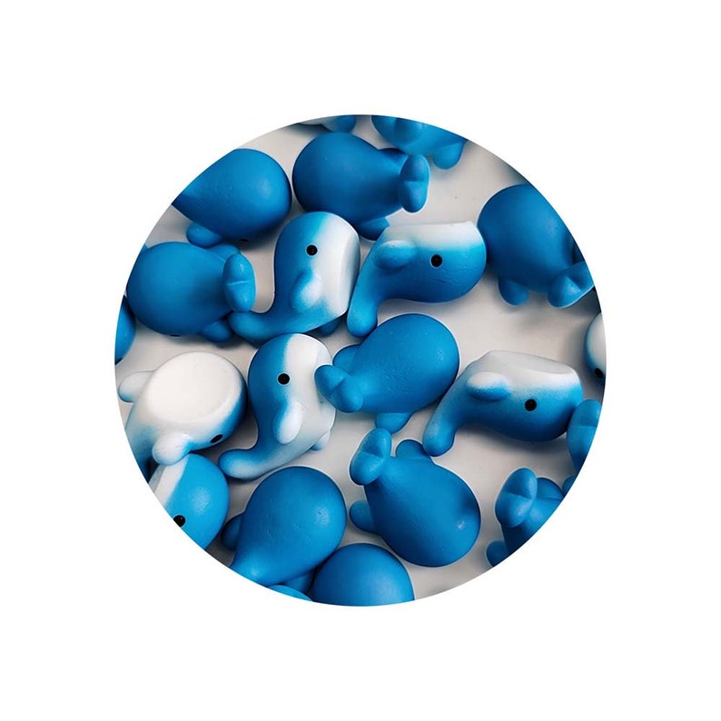 May include: A collection of blue and white whale figurines. The whales are made of a soft, squishy material and are perfect for a child's playroom or a desk decoration.