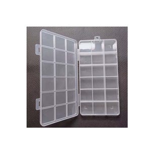 May include: A clear plastic organizer box with multiple compartments. The box is open, revealing a grid-like interior designed for storing small items. The box has a hinged lid and a secure latch. The background is a dark gray surface.