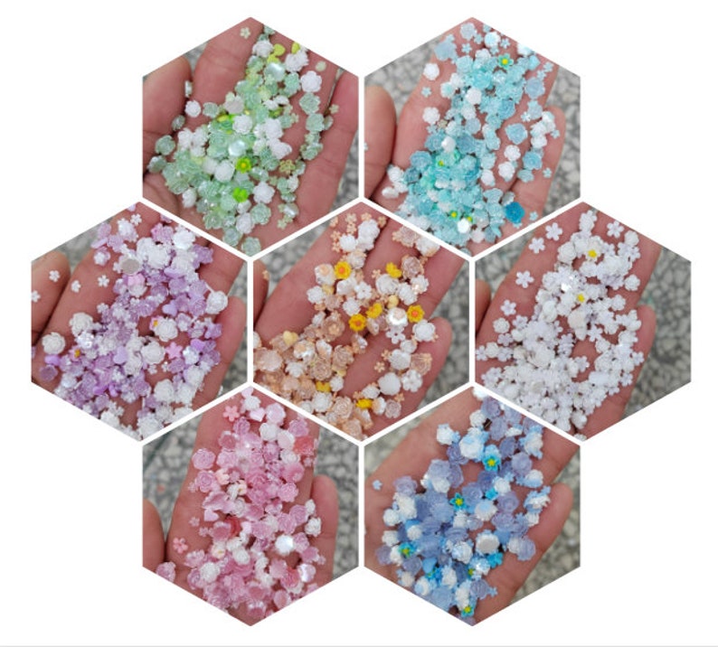 May include: Assortment of six colors of small flower-shaped sprinkles. The colors are light green, lavender, yellow, white, pink, and light blue.