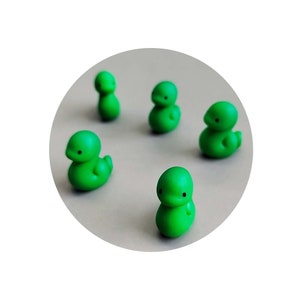 May include: Five green rubber duck figurines on a grey background. The ducks are all facing forward with their beaks open.