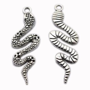 May include: Two silver snake charms, one with a textured, scaly design and the other with a striped design. Both charms are ideal for adding a touch of whimsy to jewellery projects.