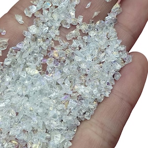 Könnte beinhalten: Eine Handvoll irisierender, klarer Glasstücke, perfekt zum Basteln oder um Dekorationsprojekten im Haus einen Hauch von Glamour zu verleihen.