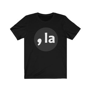 May include: Black t-shirt with a white circle containing a comma and the word "la" in white.