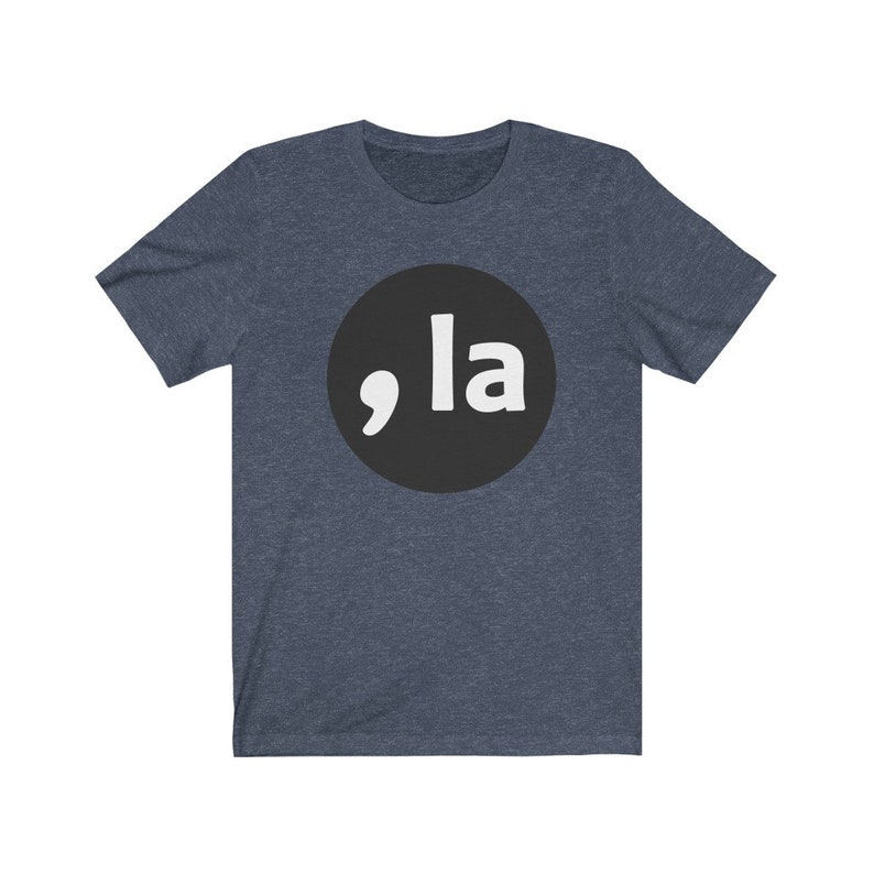 May include: A dark blue t-shirt with a black circle and white text that says ",la" in a bold font.