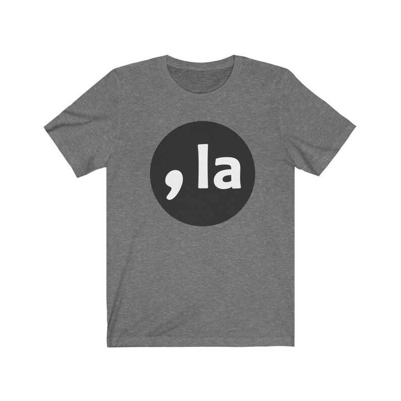 May include: A heather grey t-shirt with a black circle containing a white comma and the word "la" in white.