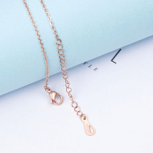Puede incluir: Un collar de cadena de oro rosa con un cierre de langosta y una peque&ntilde;a etiqueta con la palabra "925" en ella.