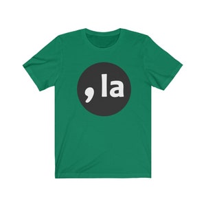 May include: A green short-sleeved t-shirt with a black circle containing a white comma and the word "la" in white.