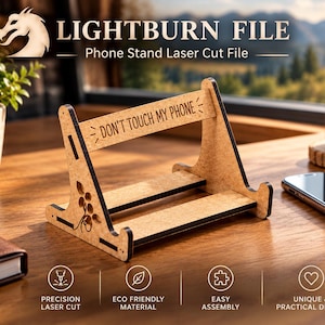 May include: A light brown laser-cut wooden phone stand featuring the engraved text "DON'T TOUCH MY PHONE" on the top crossbar and a decorative floral cutout on the side panel. The stand has a flat base and an angled support structure.