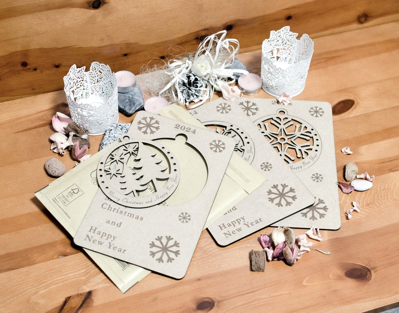 May include: Three wooden Christmas ornaments with a snowflake design and the text "Merry Christmas and Happy New Year" and "Happy New Year". The ornaments are on a wooden surface with decorative items.