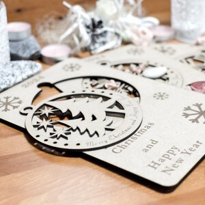 May include: Three wooden Christmas ornaments with a snowflake design and the text "Merry Christmas and Happy New Year".