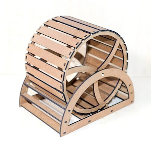 May include: A light brown wooden exercise wheel for small animals, featuring a cylindrical drum constructed from horizontal slats with dark edges, supported by a semi-circular base frame with a central circular support structure.