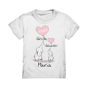 Könnte beinhalten: Weißes T-Shirt mit einer Illustration von Elefanten, die rosa herzförmige Luftballons halten. Die Ballons zeigen das Jahr '2023', die Worte 'Große Schwester' und den Namen 'Maria'. Das Design ist in Schwarz und Rosa gehalten.