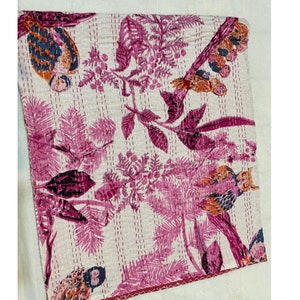 Puede incluir: Una colcha kantha rosa y blanca con un dise&ntilde;o floral y de p&aacute;jaros. La colcha est&aacute; hecha de algod&oacute;n y est&aacute; cosida a mano.