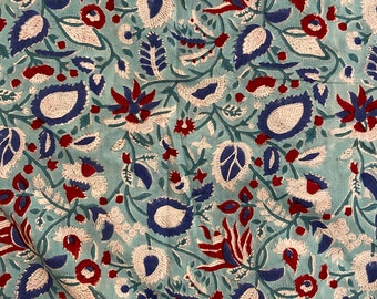 May include: A blue fabric with a white and red floral pattern. The fabric has a traditional Indian design with intricate details.