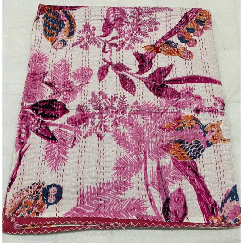 Puede incluir: Colcha kantha rosa y blanca con un patr&oacute;n floral y de p&aacute;jaros. La colcha est&aacute; cosida a mano y presenta una variedad de p&aacute;jaros y flores.