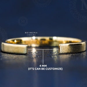 Puede incluir: Un anillo dorado con un diseño plano y rectangular. El anillo tiene una abertura de 4 mm y el texto "(IT'S CAN BE CUSTOMIZE)". El anillo es de Mesmora Jewelry, sobre un fondo azul oscuro.