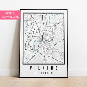 Puede incluir: Un mapa en blanco y negro de Vilnius, Lituania, con un río azul que lo atraviesa. El nombre de la ciudad está impreso en negrita, en letras negras debajo del mapa.