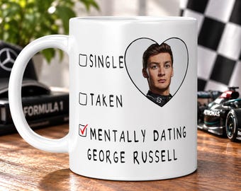 May include: A white ceramic mug featuring a checklist design with the options Single and Taken left blank, and a red checkmark next to the text Mentally Dating George Russell, accompanied by a heart-shaped portrait of the Formula 1 driver.